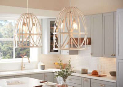 Carolina Electrical Supply Company | ivory caged light fixtures with three bulbs in each over the kitchen island in a cream and gray colored kitchen